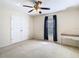 Neutral bedroom with a ceiling fan, double door closet and a window with dark curtains at 469 Fairbanks Rd, Spring Hill, FL 34608
