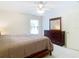 Bright bedroom features a ceiling fan, window, and dresser with matching mirror at 469 Fairbanks Rd, Spring Hill, FL 34608