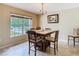 Dining room with large window, chandelier, and a wooden table with seating for five at 469 Fairbanks Rd, Spring Hill, FL 34608