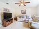 Comfortable living room features a ceiling fan, recliner love seat, and modern television on a wooden stand at 469 Fairbanks Rd, Spring Hill, FL 34608