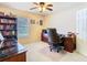 This home office features an executive desk and chair and is enhanced by a ceiling fan and neutral decor at 469 Fairbanks Rd, Spring Hill, FL 34608