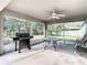 Screened-in lanai featuring a grill, patio table and chairs, and ceiling fan at 469 Fairbanks Rd, Spring Hill, FL 34608