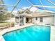 Sparkling in-ground swimming pool with screened enclosure and covered patio at 469 Fairbanks Rd, Spring Hill, FL 34608