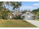 Well-maintained home exterior featuring lush landscaping, palm trees, and a two-car garage at 4739 Mahogany Ct, Land O Lakes, FL 34639