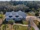 Overhead view of a single-story home featuring a spacious front porch, a curving walkway, and mature trees at 5050 Limestone Dr, Port Richey, FL 34668