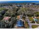 An aerial view of a home in a neighborhood surrounded by beautiful trees with a glimpse of the water at 5050 Limestone Dr, Port Richey, FL 34668