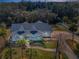 Overhead view of a single-story home with mature landscaping and sidewalks, surrounded by a lush forest canopy at 5050 Limestone Dr, Port Richey, FL 34668