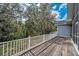 Wooden backyard deck with white railings overlooking lush greenery and mature trees at 5050 Limestone Dr, Port Richey, FL 34668