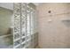 Bathroom featuring a shower with glass block, green wallpaper and tile floor at 5050 Limestone Dr, Port Richey, FL 34668