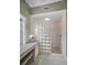 Bathroom featuring a shower enclosed with glass block and vanity area at 5050 Limestone Dr, Port Richey, FL 34668