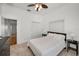 Well-lit bedroom with a ceiling fan, closet, and carpet, complemented by a queen bed and minimalist decor at 5050 Limestone Dr, Port Richey, FL 34668