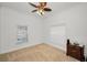 Bedroom features neutral carpet, ceiling fan, and dual windows for natural light at 5050 Limestone Dr, Port Richey, FL 34668