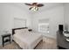 Comfortable carpeted bedroom with natural light and a large bed, featuring a ceiling fan and minimalist decor at 5050 Limestone Dr, Port Richey, FL 34668
