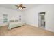 Bright bedroom features neutral carpet, ceiling fan, and attached bathroom for added convenience at 5050 Limestone Dr, Port Richey, FL 34668