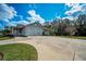 Spacious driveway leading to an attached garage, complemented by well-manicured landscaping at 5050 Limestone Dr, Port Richey, FL 34668