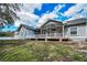Back of home featuring screened porch and exterior deck, perfect for outdoor relaxation and enjoying the scenery at 5050 Limestone Dr, Port Richey, FL 34668