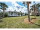 Charming single-story home featuring a large, covered front porch with white railings and surrounded by palm trees at 5050 Limestone Dr, Port Richey, FL 34668