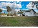 Charming home exterior with well-manicured lawn, mature trees, and side deck at 5050 Limestone Dr, Port Richey, FL 34668