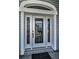 Close-up of a white front door featuring decorative glass and detailed trim at 5050 Limestone Dr, Port Richey, FL 34668