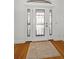 Close-up of the front door featuring decorative glass and hardwood floors in the foyer at 5050 Limestone Dr, Port Richey, FL 34668