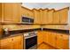 Kitchen with stainless steel appliances, granite countertops, and honey colored wood cabinets at 5050 Limestone Dr, Port Richey, FL 34668