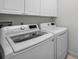 Efficient laundry room featuring modern LG appliances and ample cabinet storage for a streamlined space at 5050 Limestone Dr, Port Richey, FL 34668