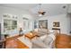 Spacious living room featuring a large grey sofa, wood floors, and access to an outdoor porch at 5050 Limestone Dr, Port Richey, FL 34668