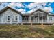 Rear exterior of the home featuring a screened-in porch and backyard deck at 5050 Limestone Dr, Port Richey, FL 34668