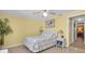 Comfortable bedroom featuring a ceiling fan, tiled flooring, and bright, yellow walls at 5061 Ensign Loop, New Port Richey, FL 34652