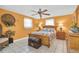 Inviting bedroom featuring tiled floors, a ceiling fan, and warm, yellow walls at 5061 Ensign Loop, New Port Richey, FL 34652
