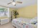 Cozy bedroom featuring a ceiling fan, tiled flooring, and bright, yellow walls at 5061 Ensign Loop, New Port Richey, FL 34652