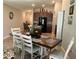 Open dining area featuring a rustic table with seating for six, adjacent to the kitchen at 5143 Sable Chime Dr, Wimauma, FL 33598