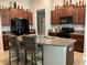 Kitchen with granite countertops, dark wood cabinetry and bar stool seating at the island at 5143 Sable Chime Dr, Wimauma, FL 33598