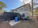 Back of house featuring an enclosed screened-in porch, AC unit, trash receptacles and partial view of yard at 5231 Corvette Dr, Tampa, FL 33624