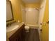 Bathroom with a shower-tub combo, granite vanity, and wood-look flooring at 5231 Corvette Dr, Tampa, FL 33624