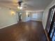 Inviting living room featuring wood floors, ceiling fan, and stylish light fixtures, with an open layout leading into the kitchen at 5231 Corvette Dr, Tampa, FL 33624