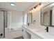 Modern bathroom with dual vanities, sleek fixtures, a soaking tub, and a glass-enclosed shower at 5357 Greystone Dr, Spring Hill, FL 34609