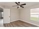 A modern bedroom features a ceiling fan, wood-look flooring, and neutral walls at 5357 Greystone Dr, Spring Hill, FL 34609