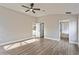 Large primary bedroom with light wood floors and an ensuite bathroom and walk in closet at 5357 Greystone Dr, Spring Hill, FL 34609