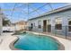 A screened-in pool area includes a spa and is surrounded by a safety fence at 5357 Greystone Dr, Spring Hill, FL 34609