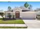 Charming single-story home featuring well-manicured landscaping, a two-car garage, and a welcoming front entrance at 5903 War Admiral Dr, Wesley Chapel, FL 33544