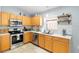 Cozy kitchen featuring stainless steel appliances, tile backsplash, quartz countertops, and a stainless steel sink at 5903 War Admiral Dr, Wesley Chapel, FL 33544