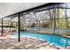 Relaxing screened-in pool with a brick-paved deck and inviting outdoor seating area at 5903 War Admiral Dr, Wesley Chapel, FL 33544