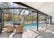 Inviting screened-in pool area with brick pavers and outdoor seating, perfect for relaxation at 5903 War Admiral Dr, Wesley Chapel, FL 33544