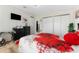 This bedroom features a bed with red rose bedding and closet with sliding doors at 610 Cobia Way, Oldsmar, FL 34677