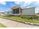 Well-kept single-story home with a screened-in porch, beautiful landscaping, and a charming stone border around the lawn at 610 Cobia Way, Oldsmar, FL 34677