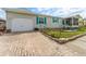 Charming single-story home featuring a paved driveway and a well-maintained lawn with beautiful stone edging at 610 Cobia Way, Oldsmar, FL 34677