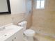 Tiled bathroom features a walk-in shower, toilet, and sink with vanity at 6301 Baldwyn Ave, New Port Richey, FL 34653