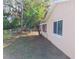 The side exterior of the home with lush grass and shade trees at 6301 Baldwyn Ave, New Port Richey, FL 34653