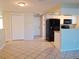 Well-lit kitchen featuring black appliances, tile flooring, and easy access to other rooms at 6301 Baldwyn Ave, New Port Richey, FL 34653